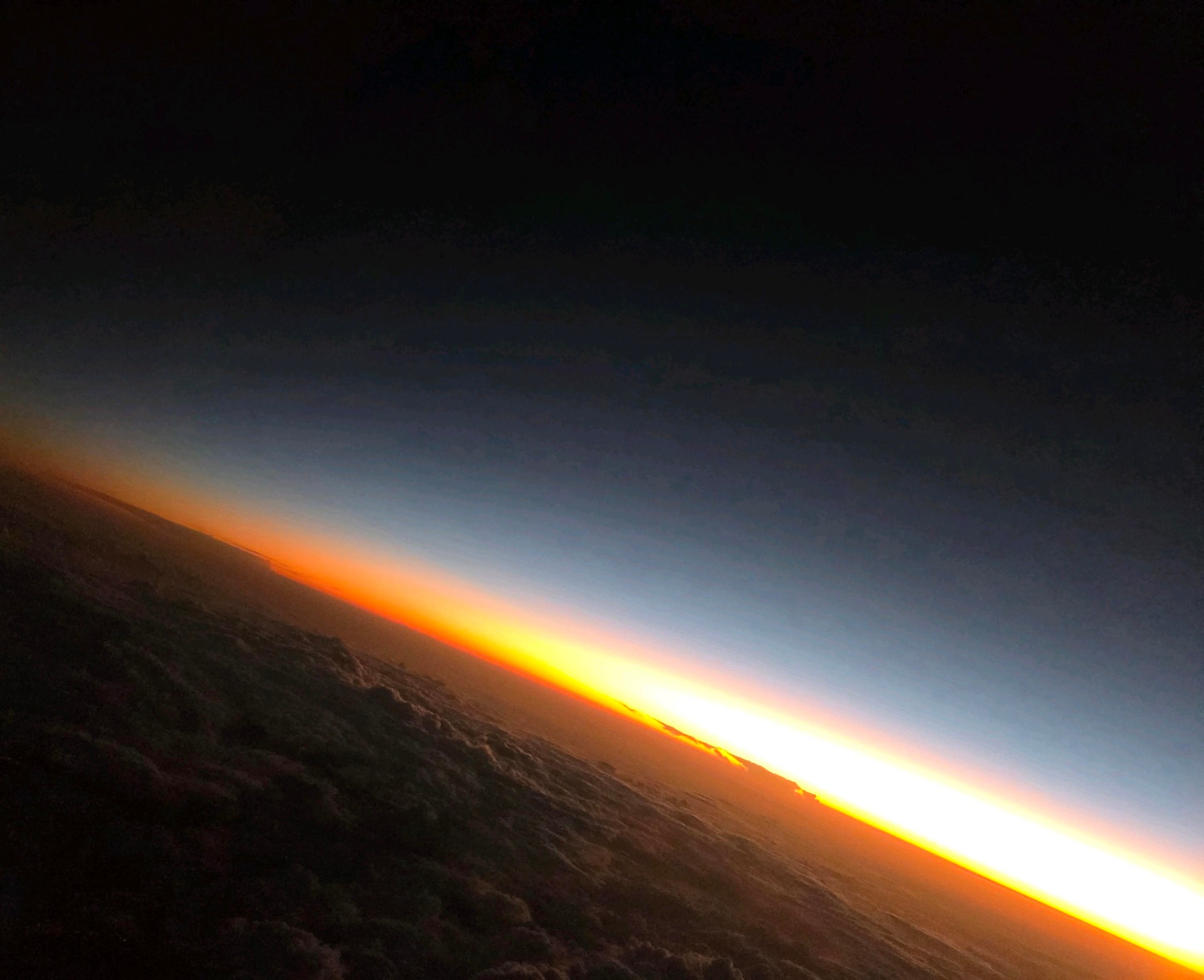 Sunrise breaking over the curvature of the earth, symbolizing clarity and ascent